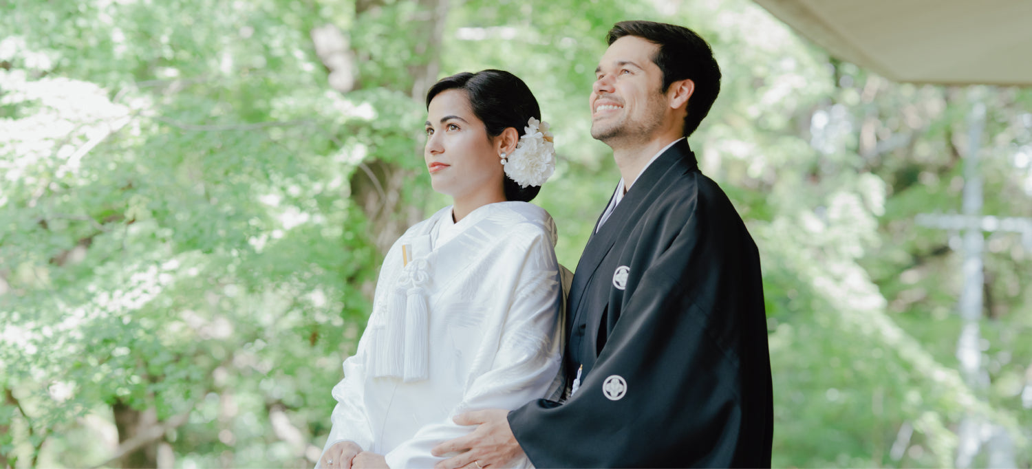 Bride and groom in traditional kimono standing together in a tranquil forest setting