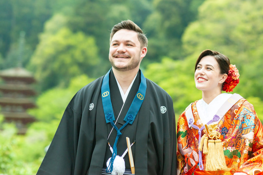 The couple smiling after the ceremony, wearing the prayer beads received from the temple