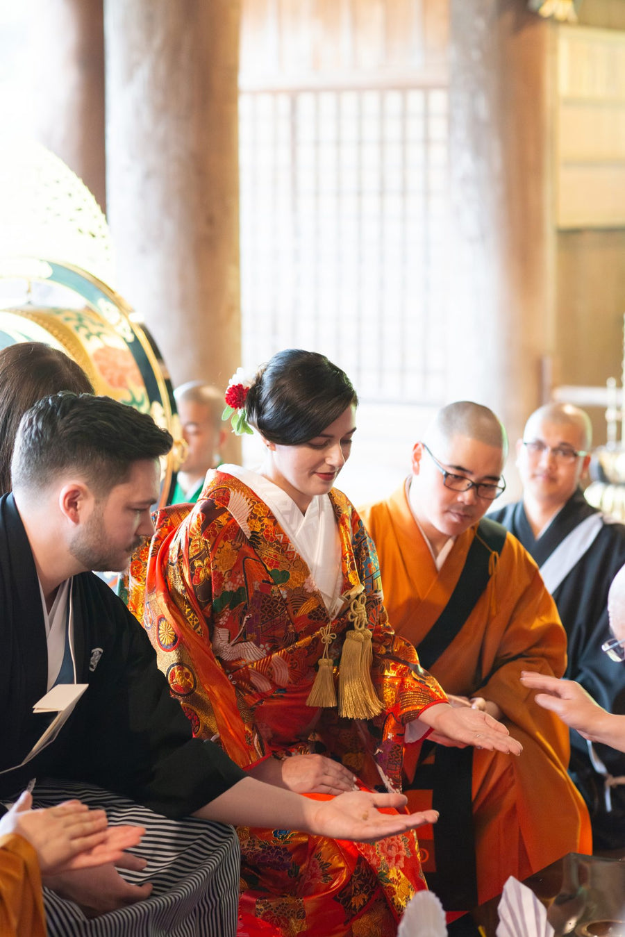 The couple purifying their hands with zukō scented powder as the Buddhist rite begins