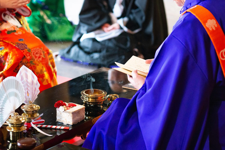 The ajari in a purple kesa reading from the sutra book at Hasedera Temple