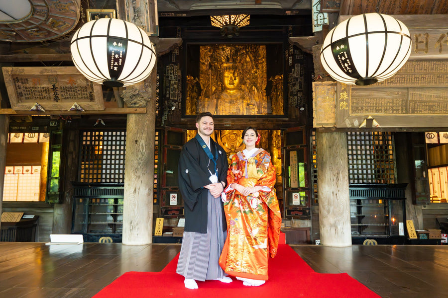 The couple on the red carpet of the main hall corridor, hanging lanterns above