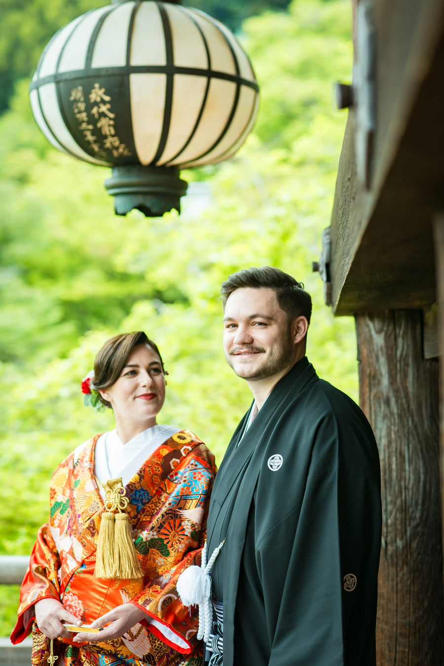 The couple smiling on the stage of Hasedera among the early-summer green