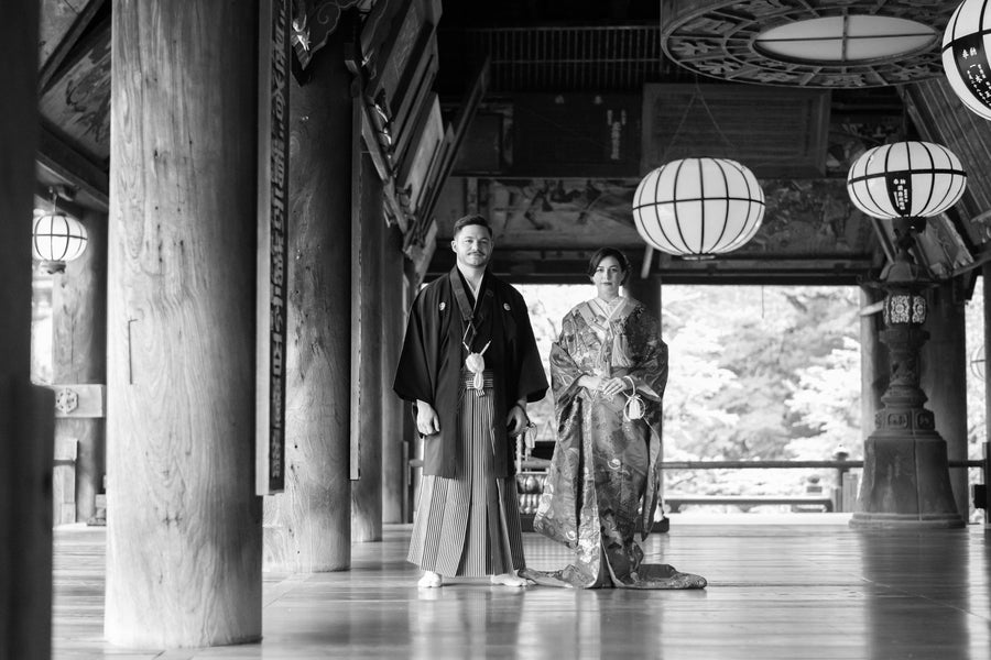The couple standing between the great pillars of the main hall, in black and white