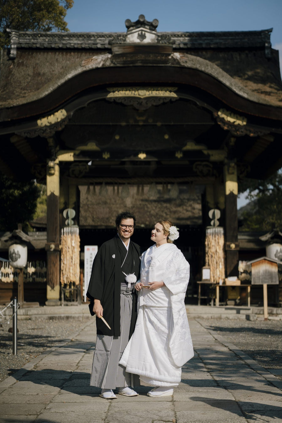 A couple from Brazil in traditional Japanese wedding attire at the gate of Toyokuni Shrine, Kyoto
